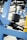 A close-up view of gym equipment focusing on a load of stacked weight plates on a metal rod. The equipment is primarily made from blue metal with black bolts and a yellow element in the corner. The background includes other gym machines and outdoor flooring.