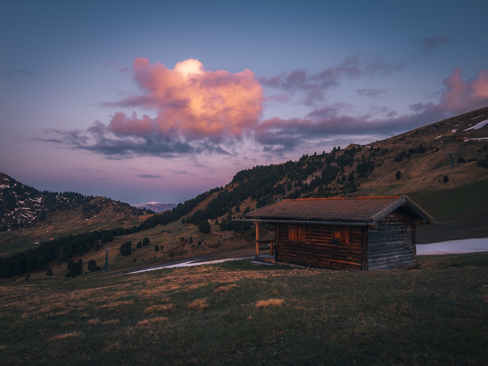 a small cabin in the middle of a grassy field