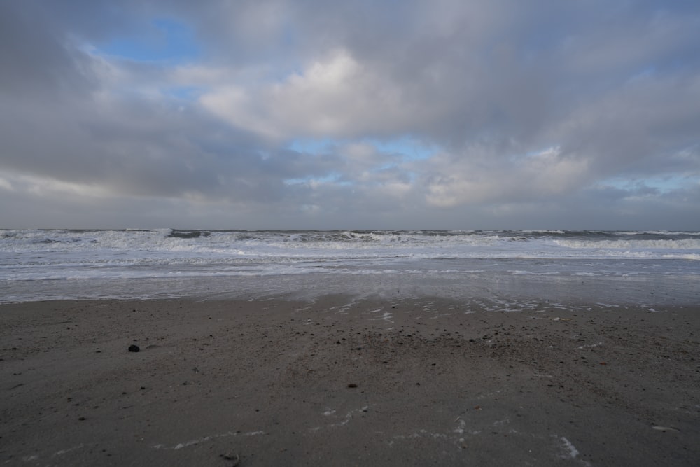 a sandy beach with waves coming in to shore