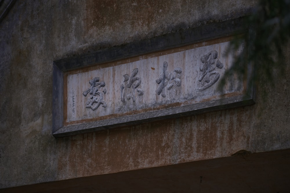 a sign on a wall with chinese writing on it