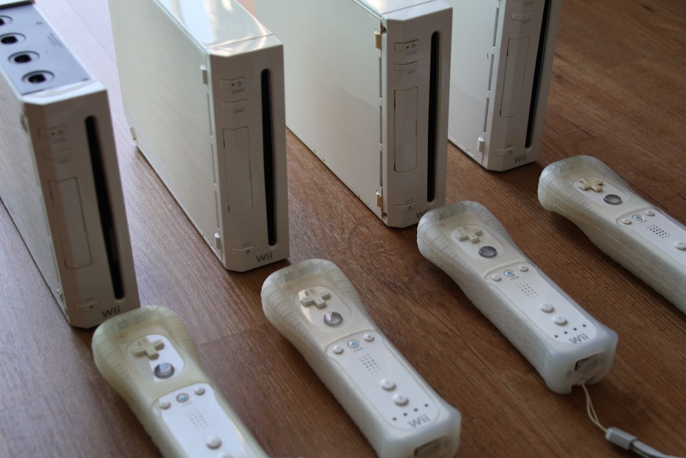 a group of video game controllers sitting on top of a wooden floor