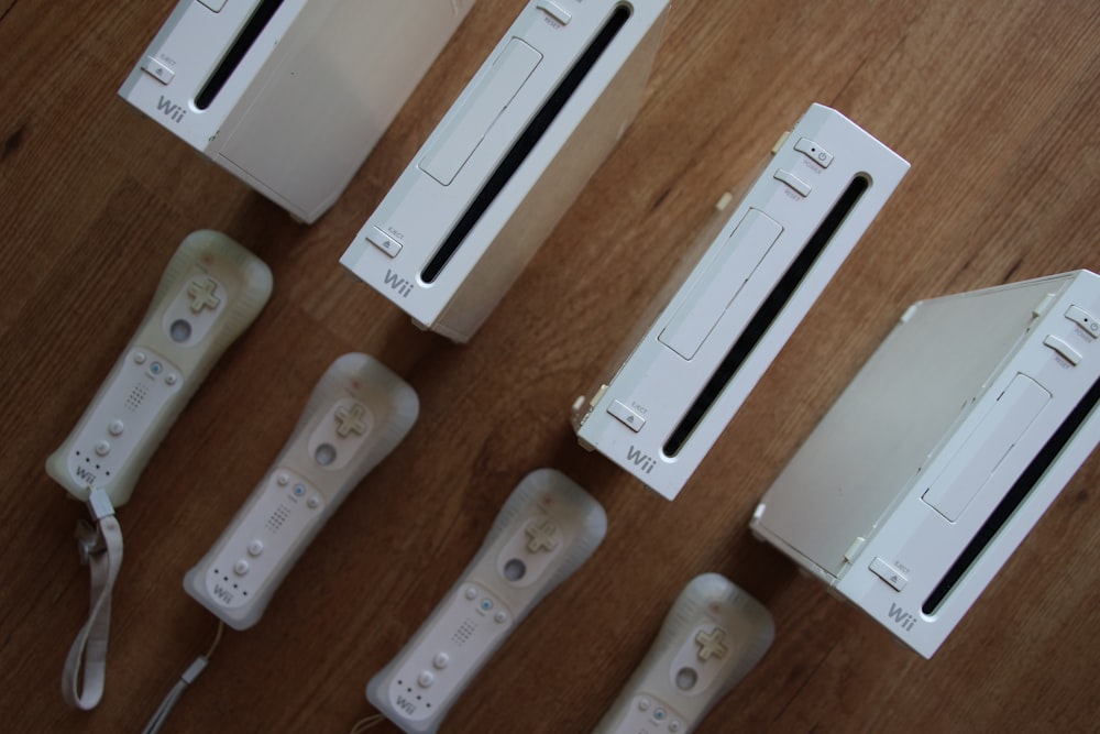 a group of video game controllers sitting on top of a wooden table