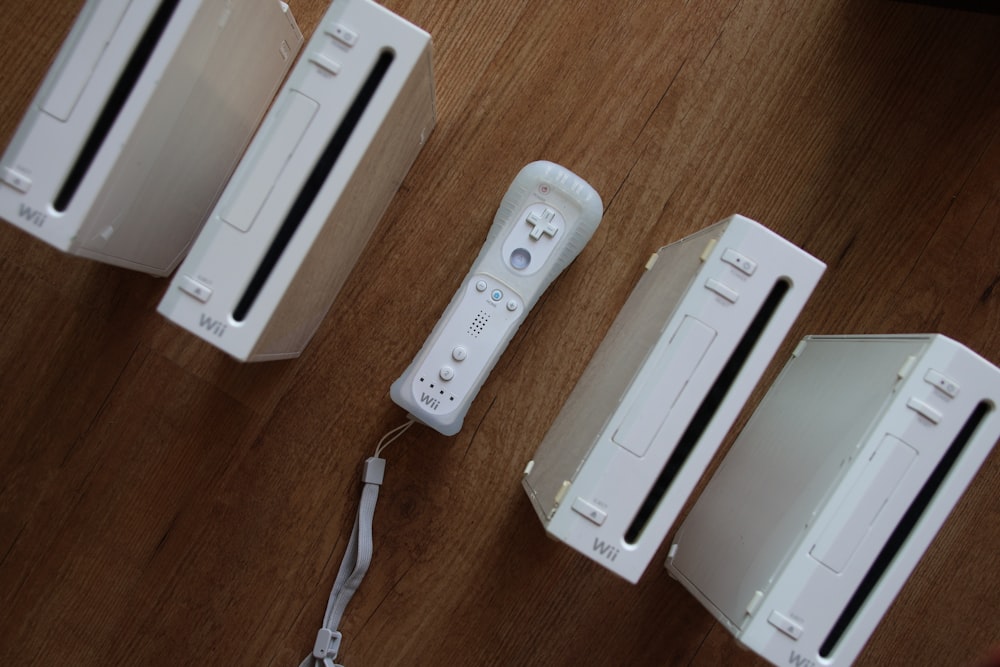 a group of nintendo wii controllers sitting on top of a wooden table