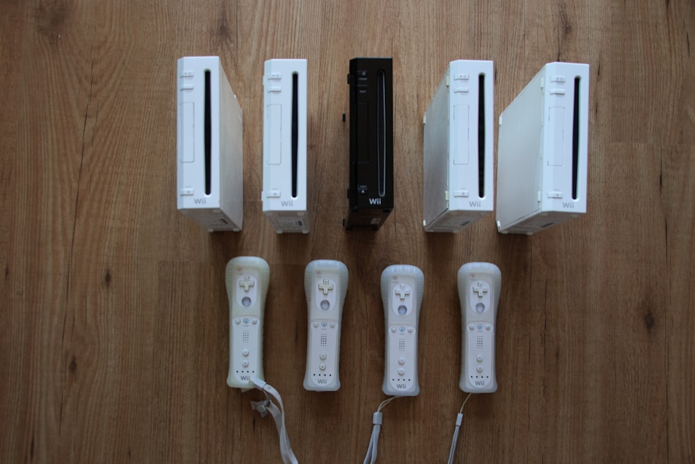 a group of nintendo wii game controllers sitting on top of a wooden floor