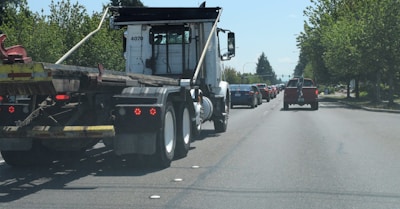 A busy highway scene featuring multiple USA-flag themed trucks moving smoothly in traffic.