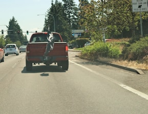 Truck crossing a border checkpoint with international flags waving.