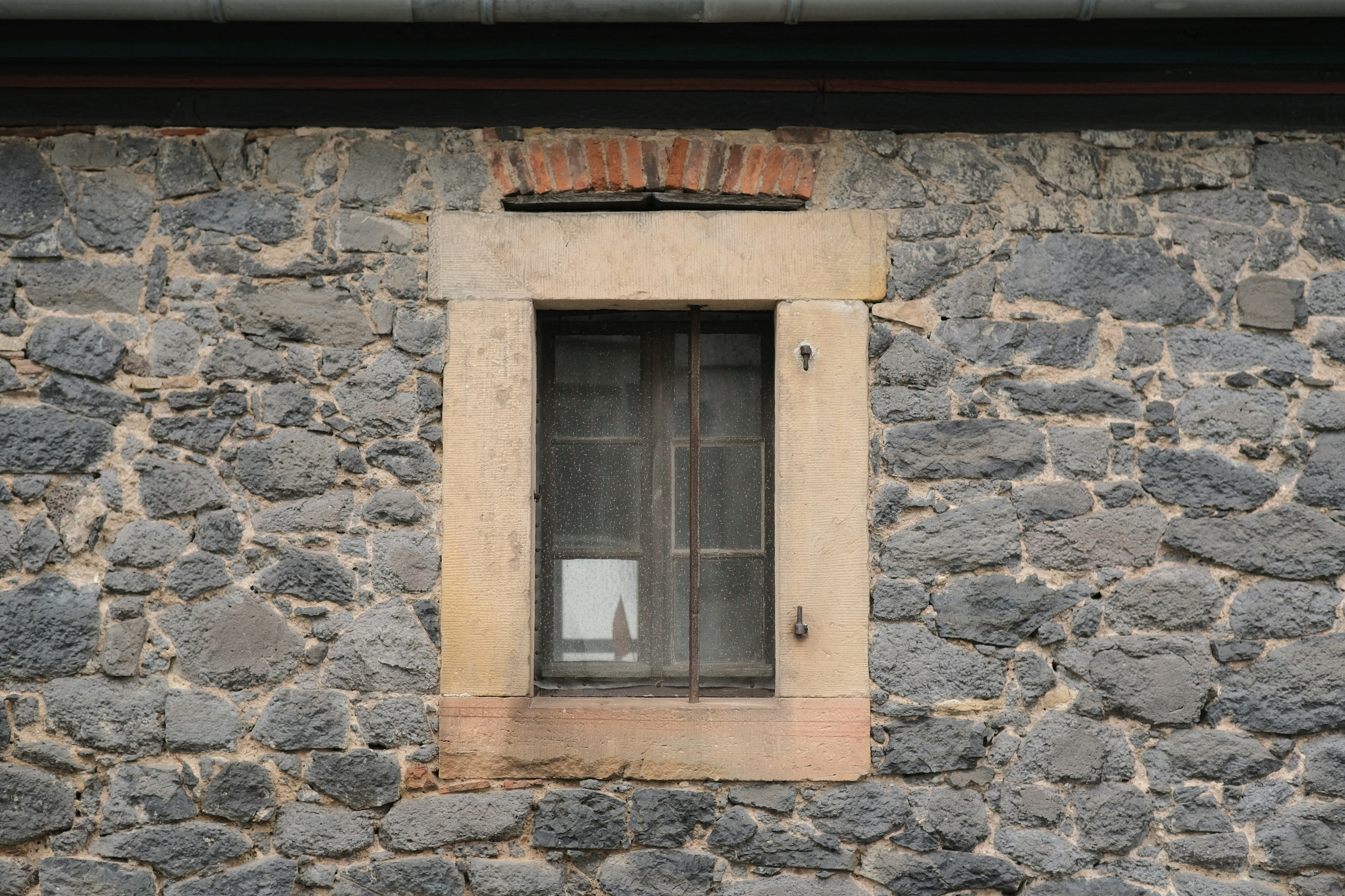 a stone building with a window and bars