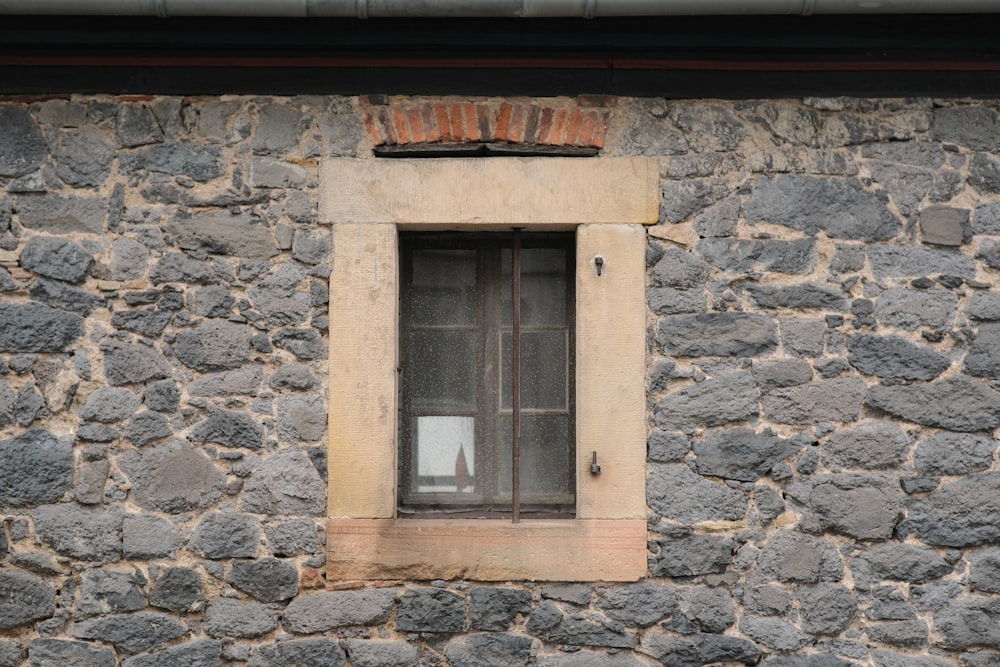 a stone building with a window and bars