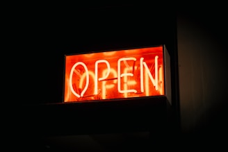A vibrant storefront sign glowing under the Florida sun in downtown Orlando.