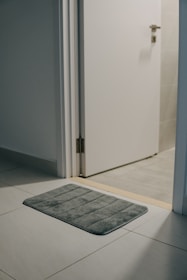 a bathroom rug on the floor in front of a door