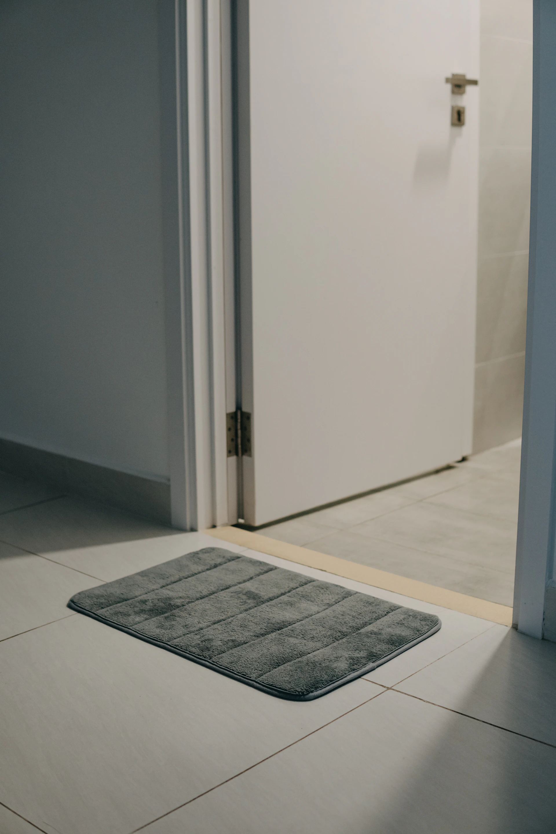 a bathroom rug on the floor in front of a door