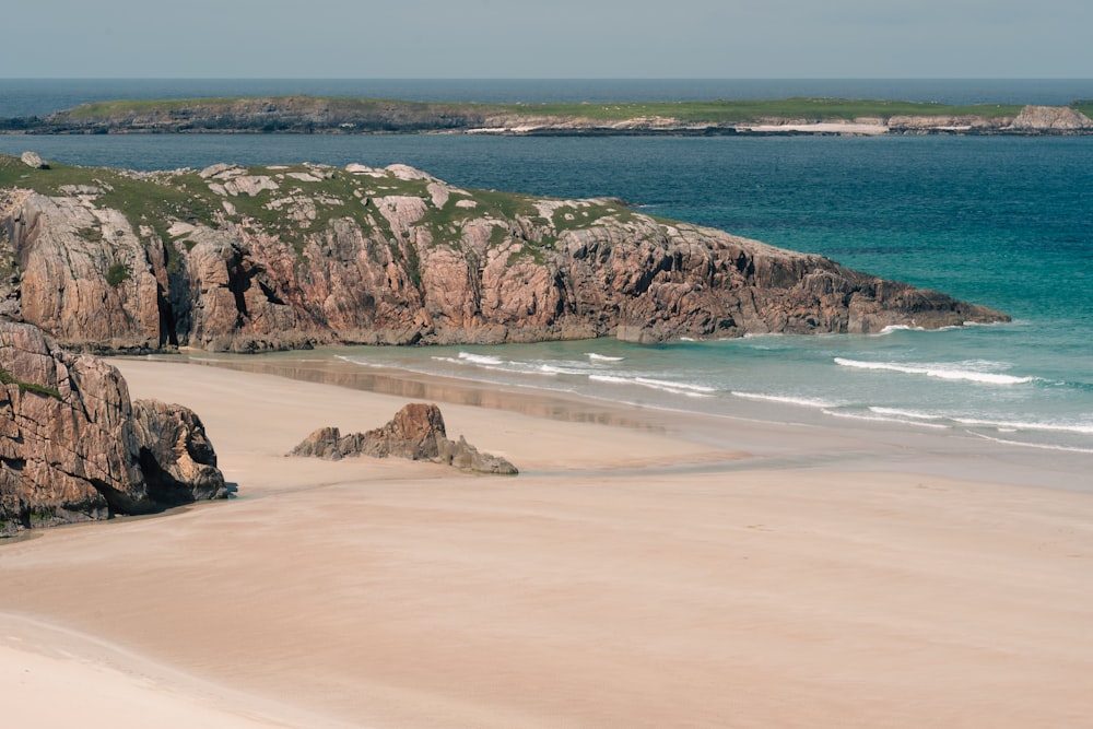 a sandy beach next to a body of water