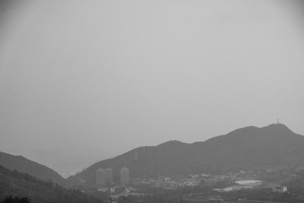 a black and white photo of a city with mountains in the background