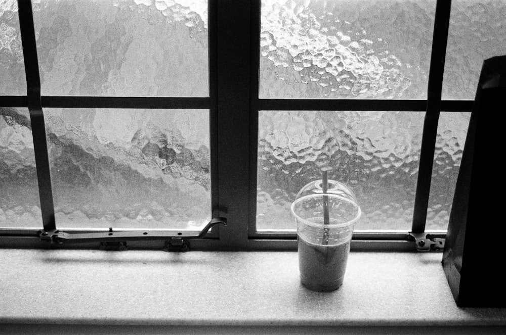 a cup sitting on top of a window sill