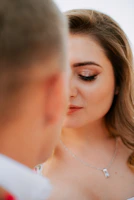 Side profile of a woman with glowing bridal makeup and subtle shimmer eyeshadow.