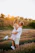A candid sunlit moment of a couple sharing a joyful embrace in a golden field.