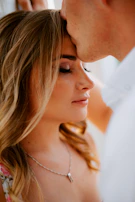 An intimate moment frozen in time: a couple sharing a gentle forehead touch, their skin glowing with rich melanin tones.