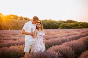 A radiant wedding scene bathed in golden light among lavender fields and ancient stone walls.