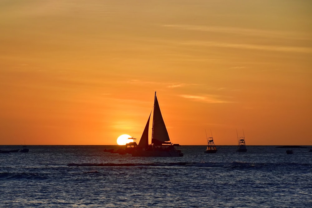 a sailboat in the ocean at sunset