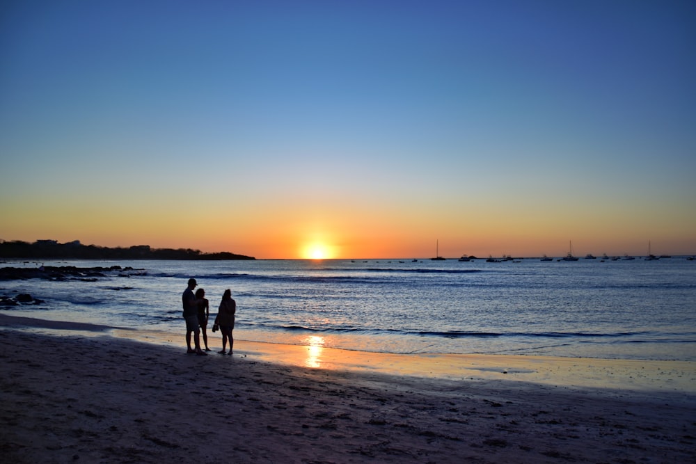 Un couple de personnes debout au sommet d’une plage de sable