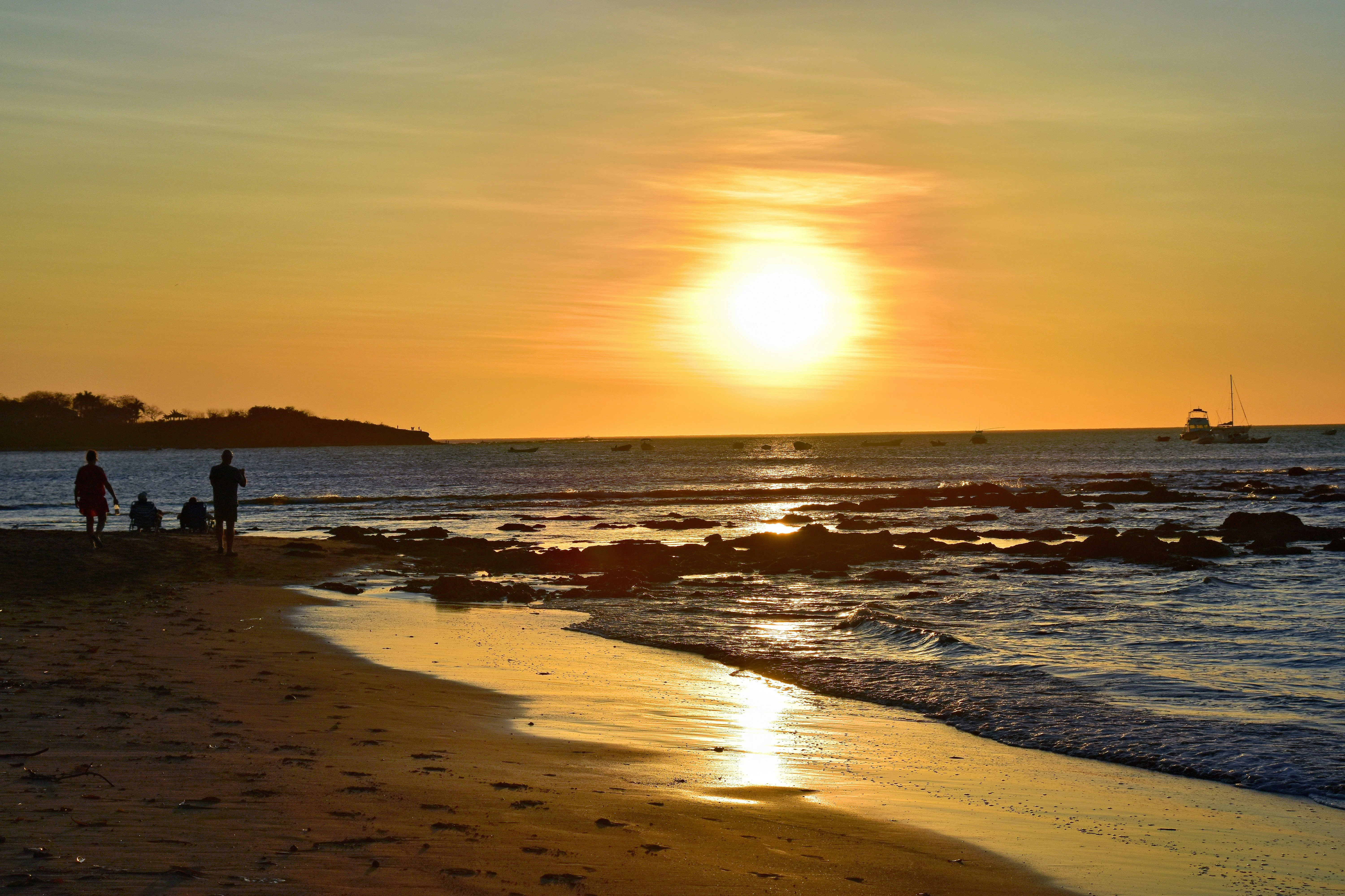 a group of people standing on top of a sandy beach, 