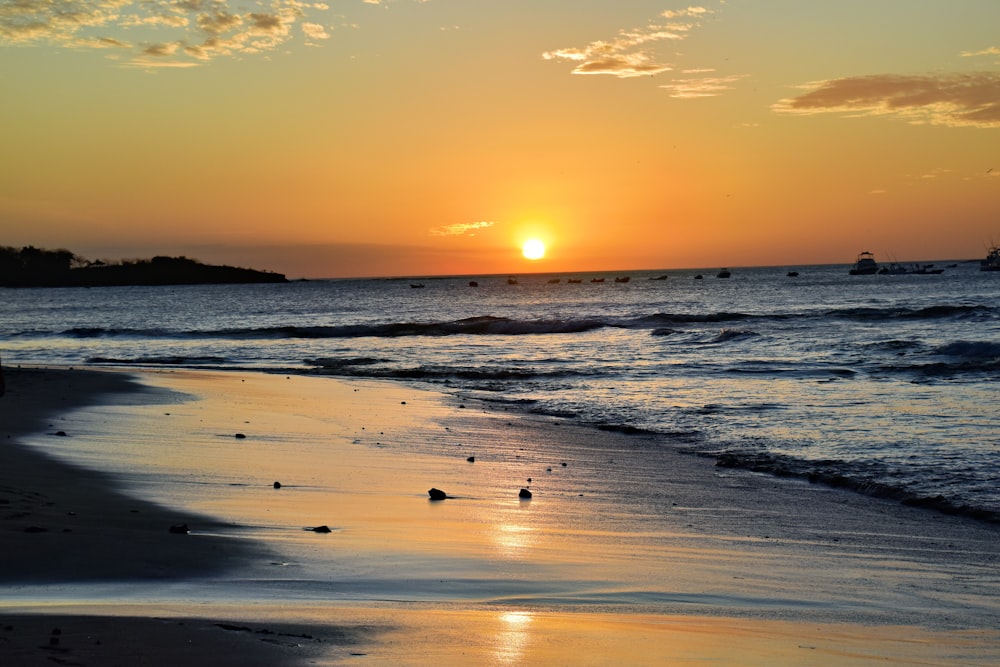 Le soleil se couche sur l’eau à la plage