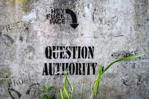 An image capturing graffiti on a city wall calling out abuse of authority.