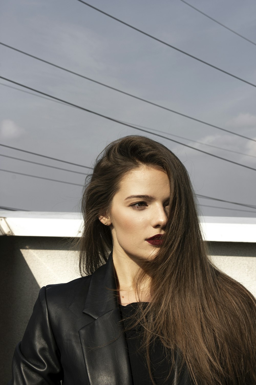 a woman with long hair standing in front of a building