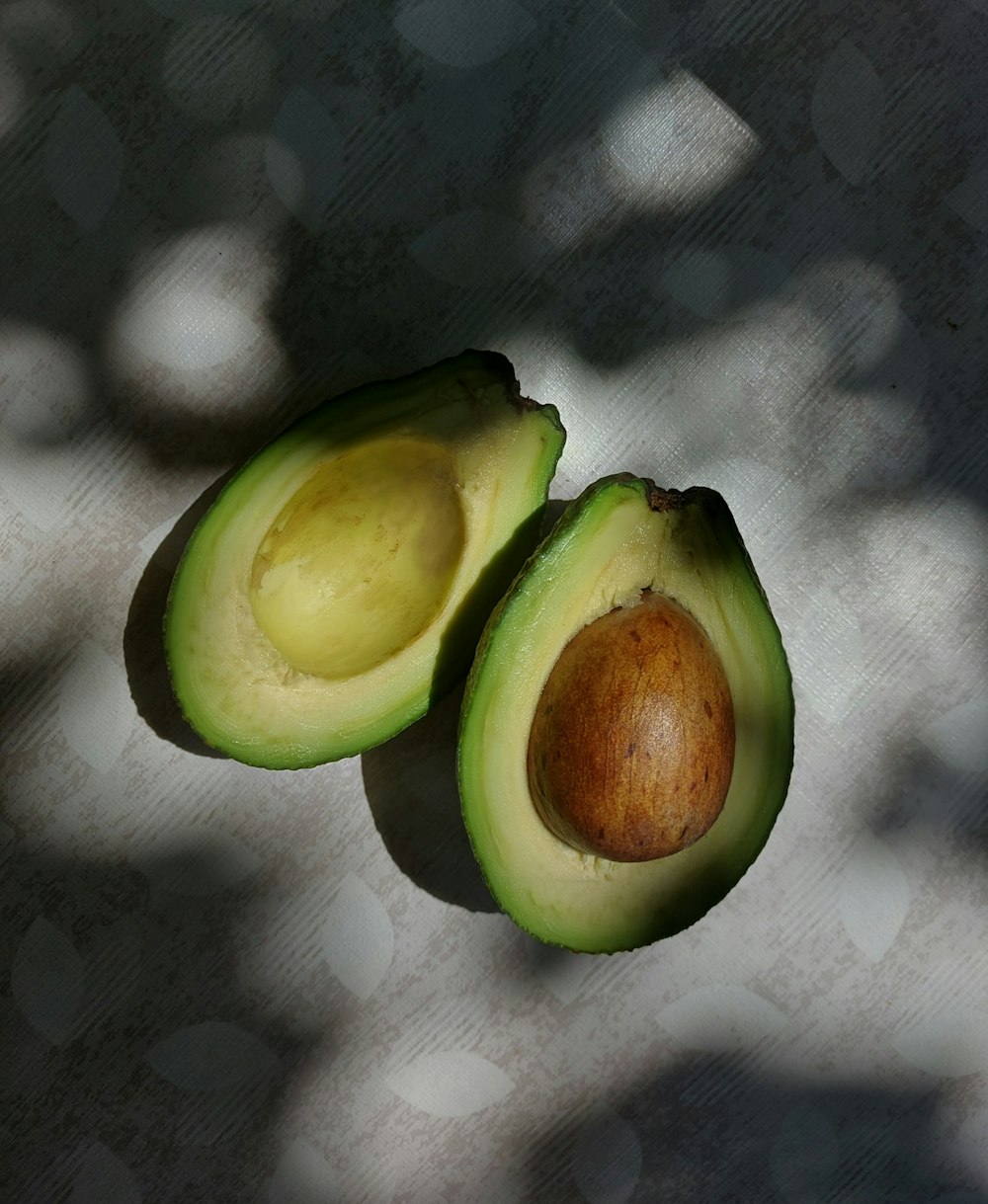 two halves of an avocado sitting on a table