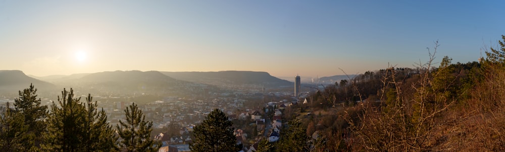 El sol se está poniendo sobre una ciudad y montañas