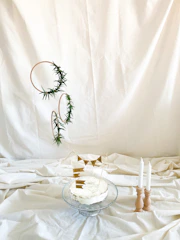 A minimalist sculpted cake in muted navy and matte gold accents, displayed on a warm cream background with soft natural lighting.