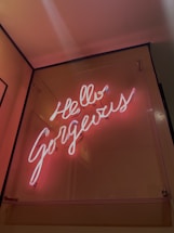 A cozy workspace with a glowing neon sign that reads 'Hello' in warm colors.