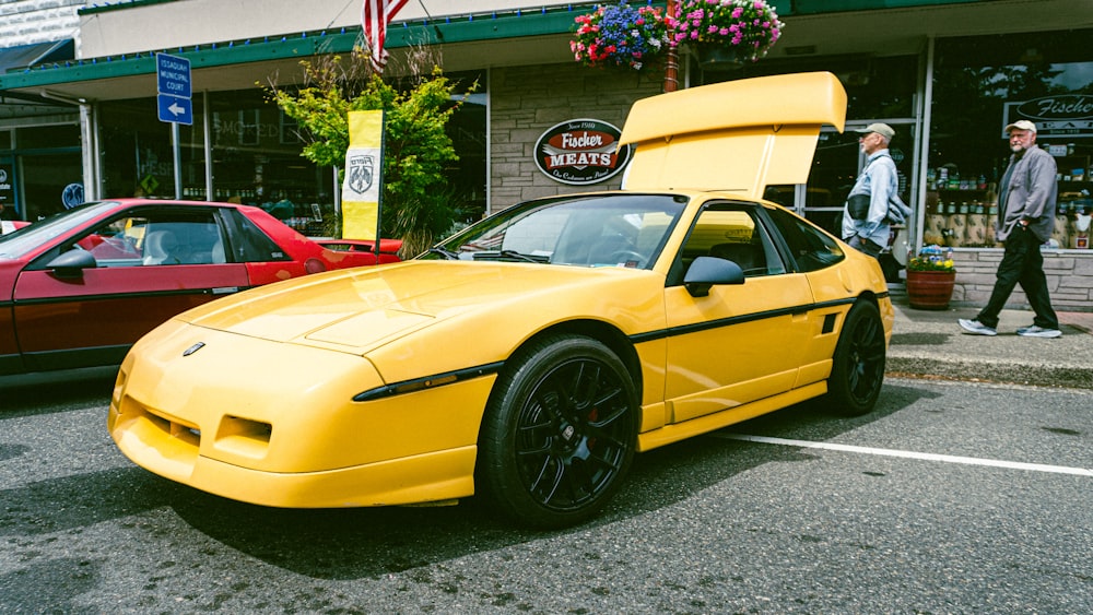 a yellow sports car parked in front of a building