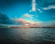 A panoramic view of multiple ships anchored in a harbor under a cloudy sky.