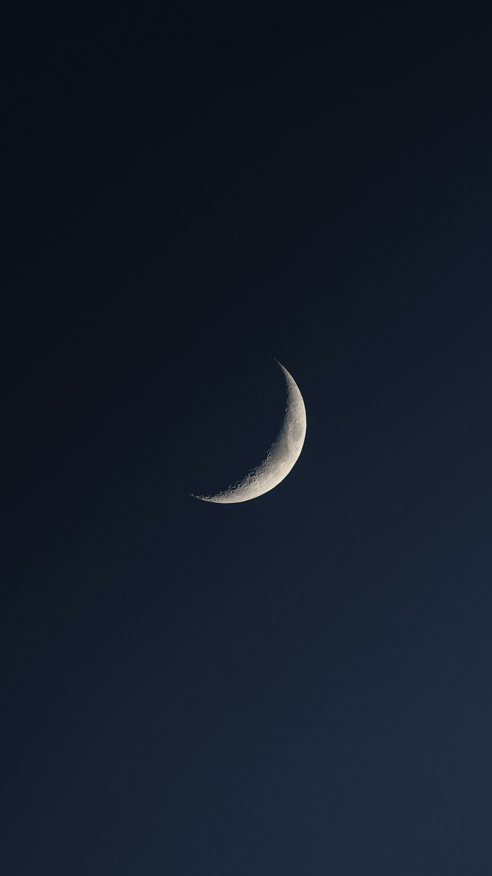 a crescent moon in a dark blue sky