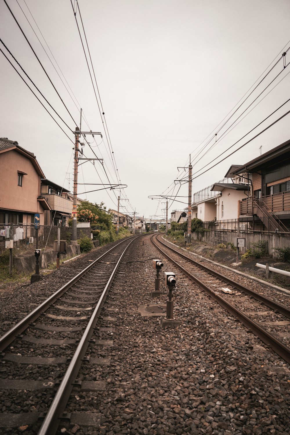 a train track with houses and power lines in the background