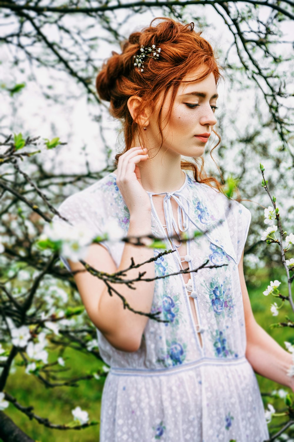 una donna in un vestito bianco in piedi su un albero