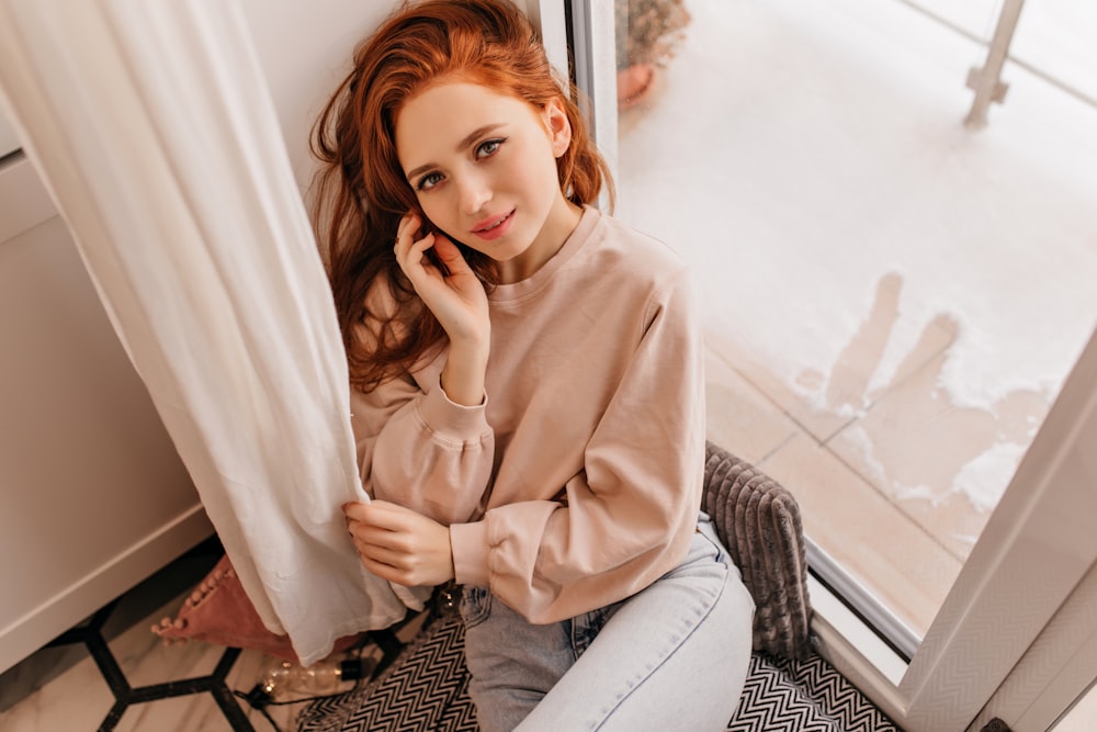 a woman sitting on a chair talking on a cell phone