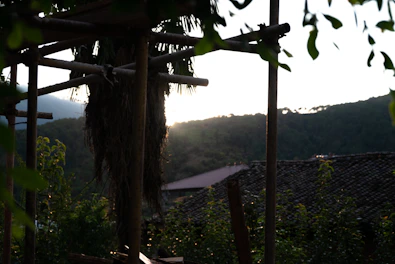 A peaceful balcony overlooking the lush gardens and distant hills at sunset.