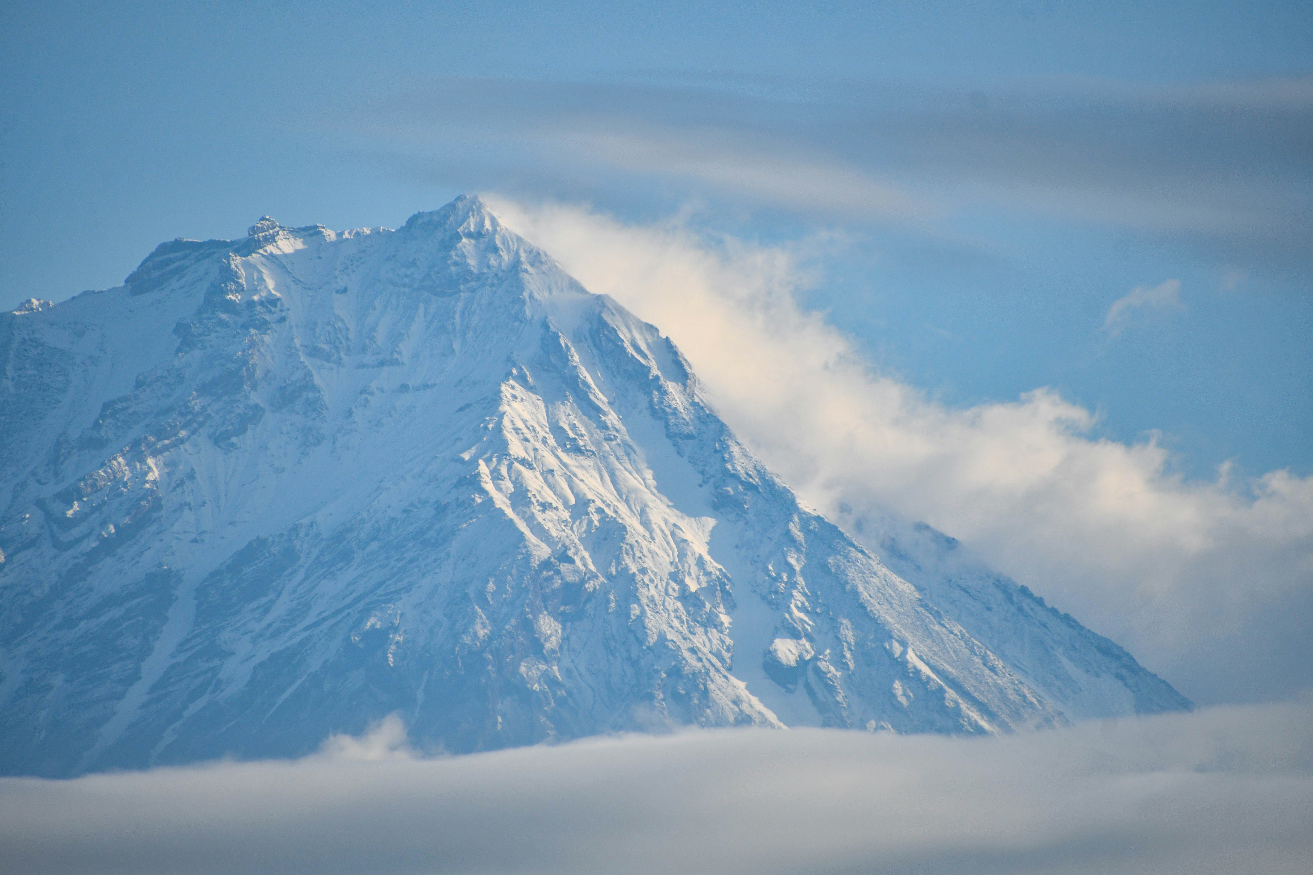 a large snow covered mountain in the middle of the day