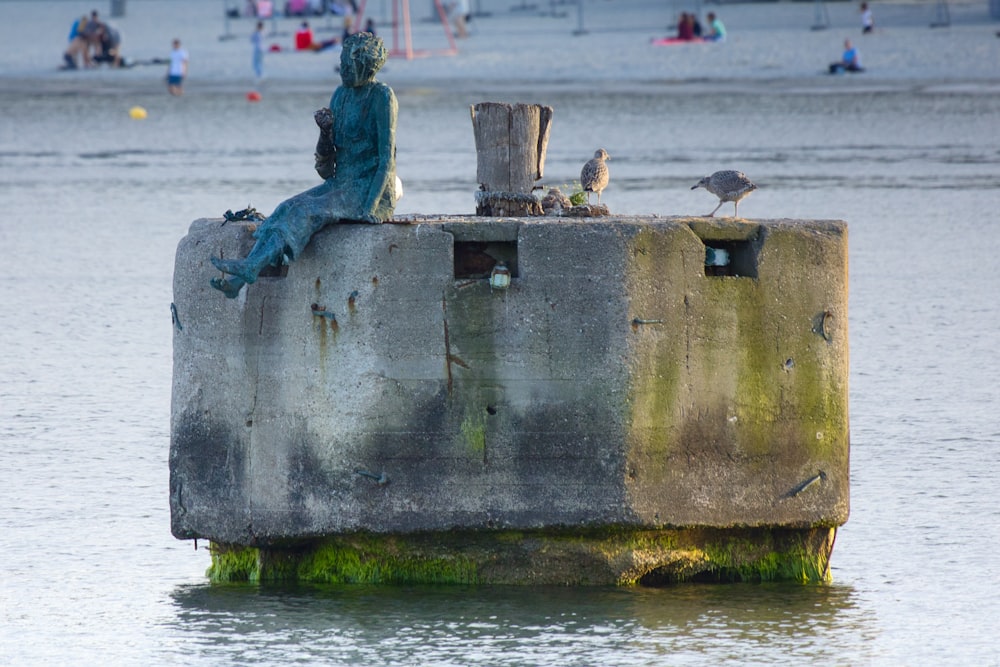 a statue sitting on top of a cement structure