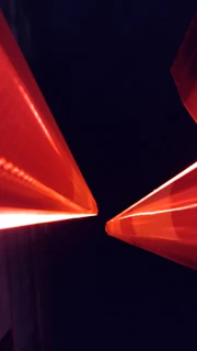A sleek black background with glowing red network grid lines converging toward a central point.