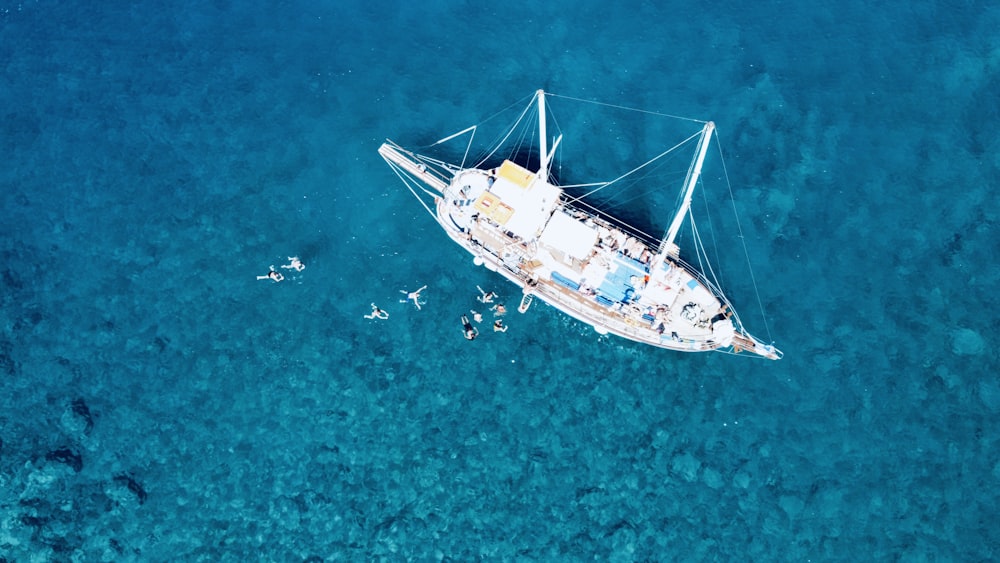 an aerial view of a sailboat in the ocean