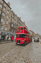 A sleek Ember coach traveling through Edinburgh's historic streets under a bright blue sky.