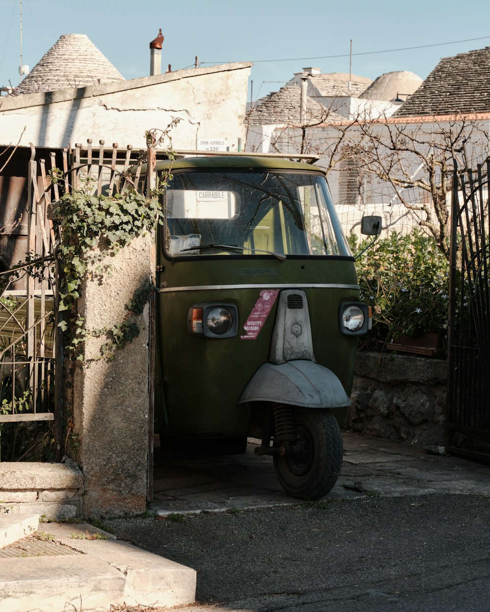 a small green van parked in front of a building