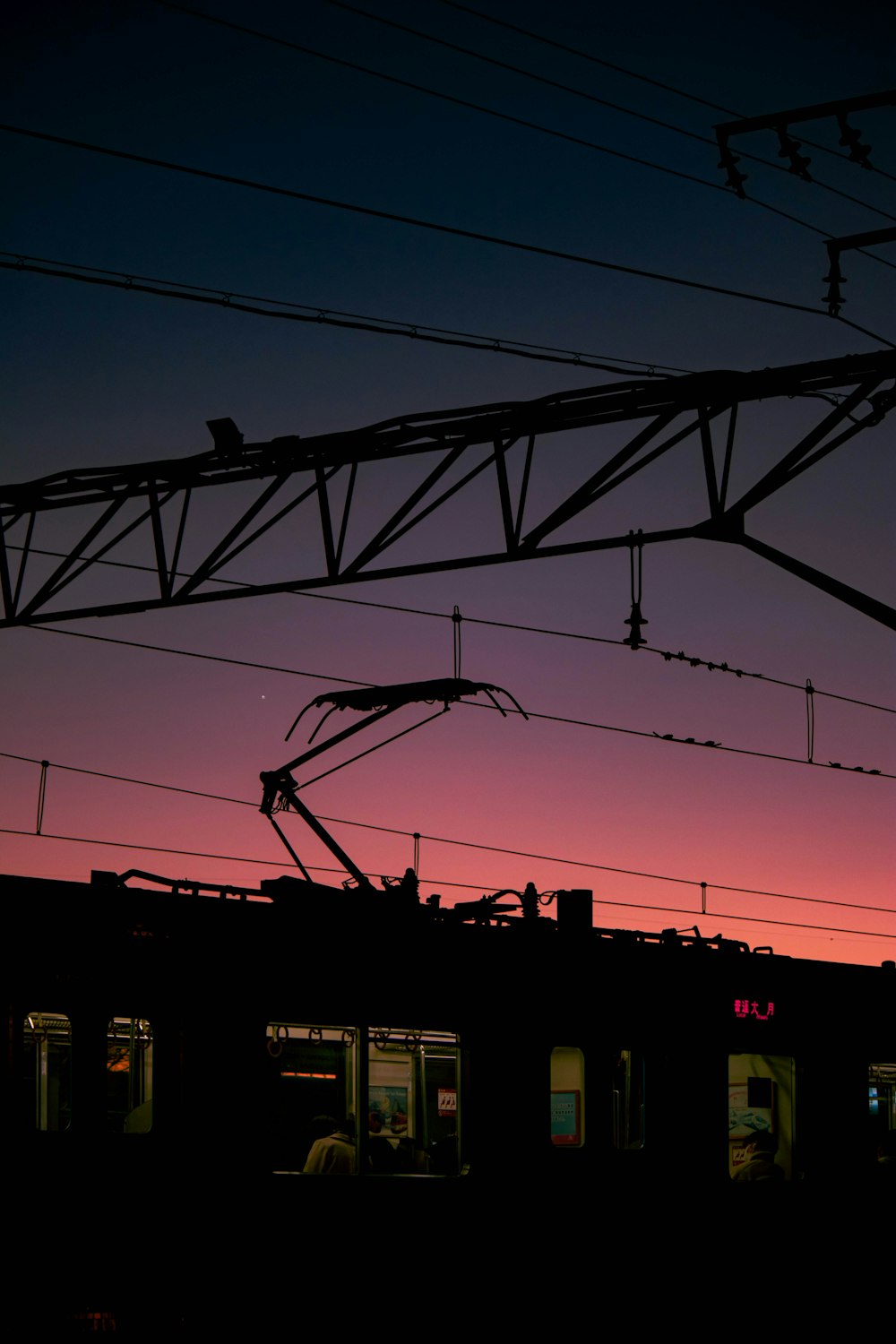 the silhouette of a train at dusk with the sky in the background