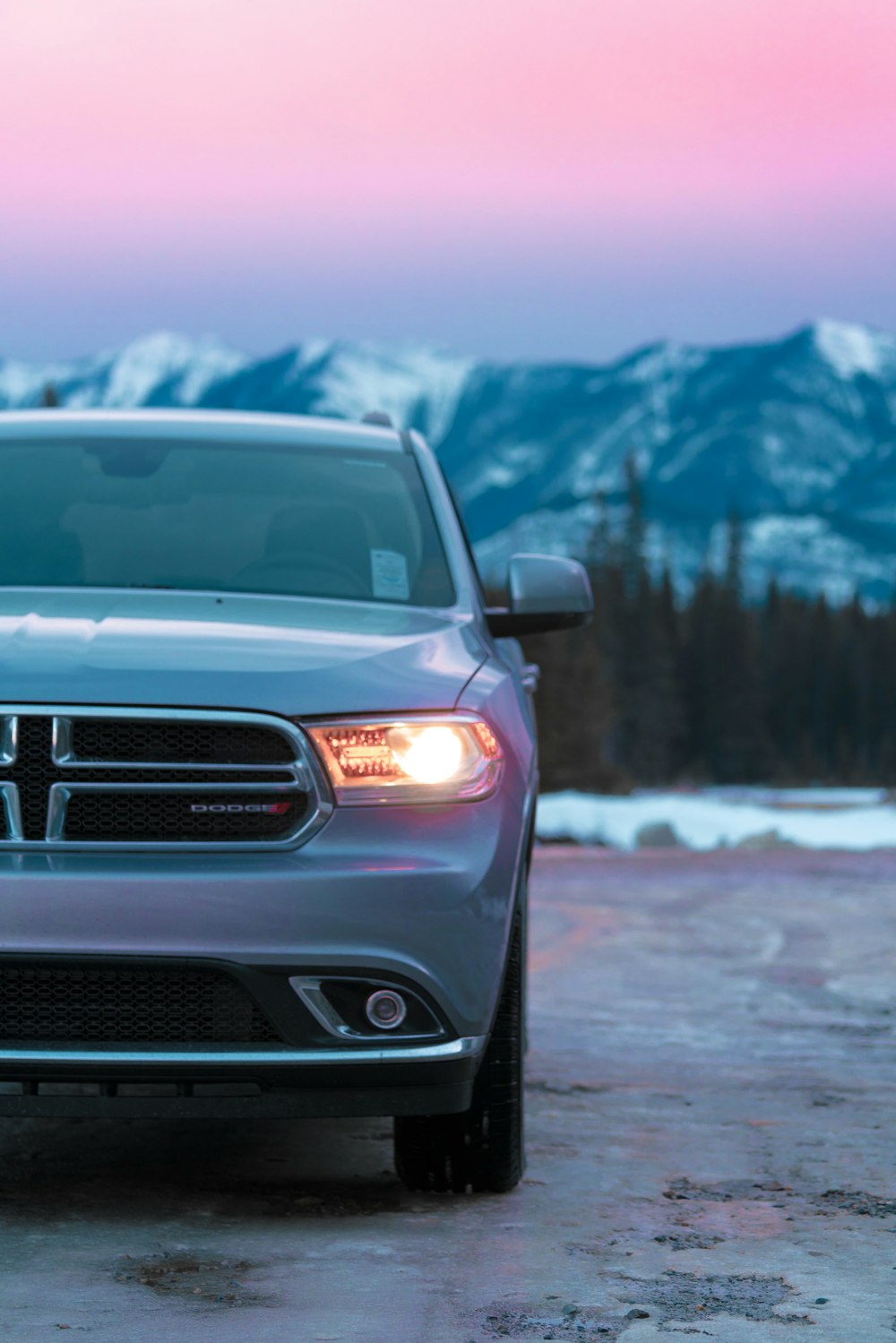 a car parked in a parking lot with mountains in the background