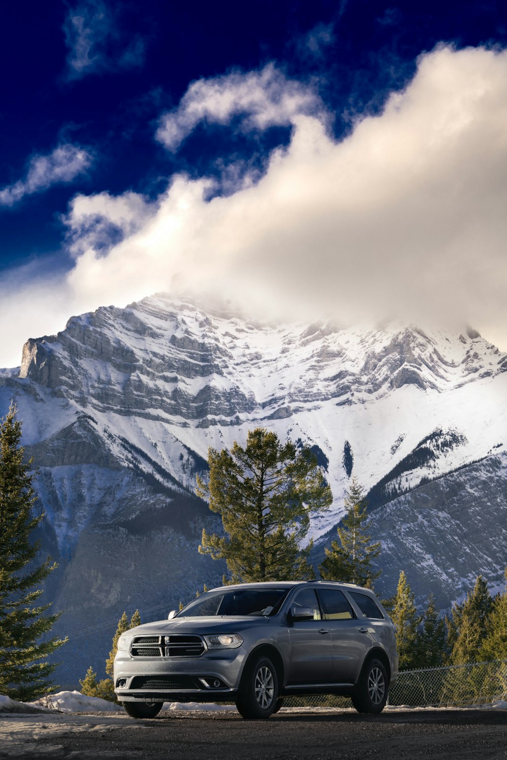 a car parked on the side of a road in front of a mountain