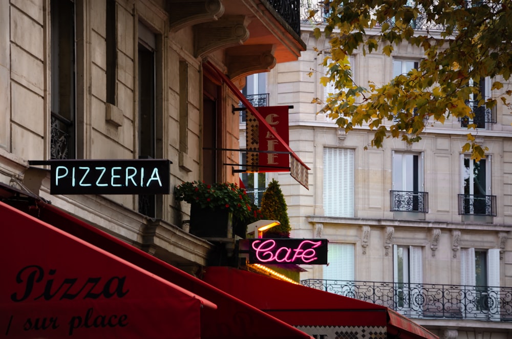 a restaurant with a red awning next to a building