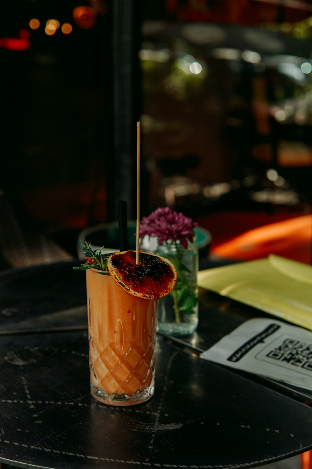 a tall glass with a drink on a table